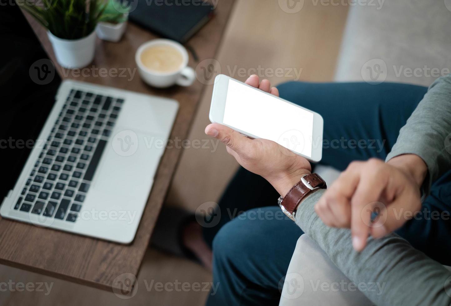 immagine della mano dell'uomo che usa, tiene in mano smartphone o mockup mobile con display bianco vuoto. la tecnologia del telefono, il design moderno digitale può utilizzare il touch screen con spazio di copia. foto