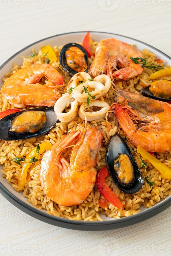 paella di mare con gamberi, vongole, cozze su riso allo zafferano foto