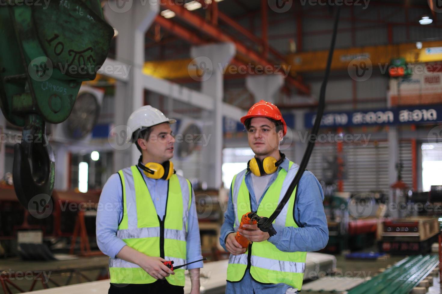 ingegnere industriale maschile che indossa un casco di sicurezza mentre si trova in una fabbrica industriale pesante. la manutenzione cercando di lavorare su macchinari industriali e controllare l'installazione del sistema di sicurezza in fabbrica. foto