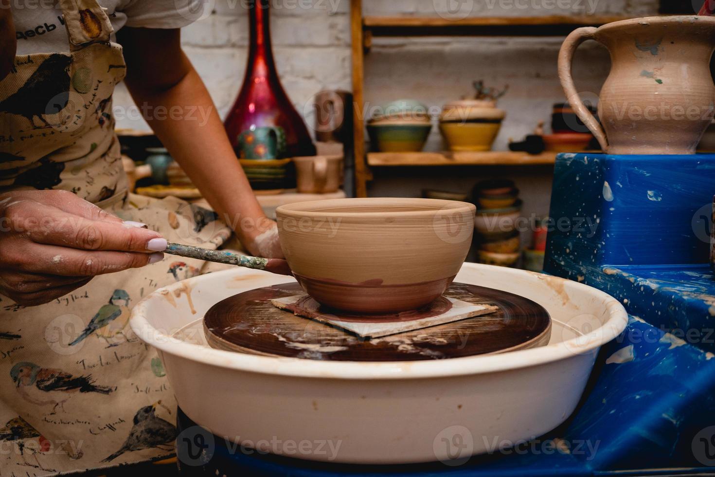 vasaio che lavora al tornio del vasaio con l'argilla. processo di produzione di stoviglie in ceramica nel laboratorio di ceramica. foto