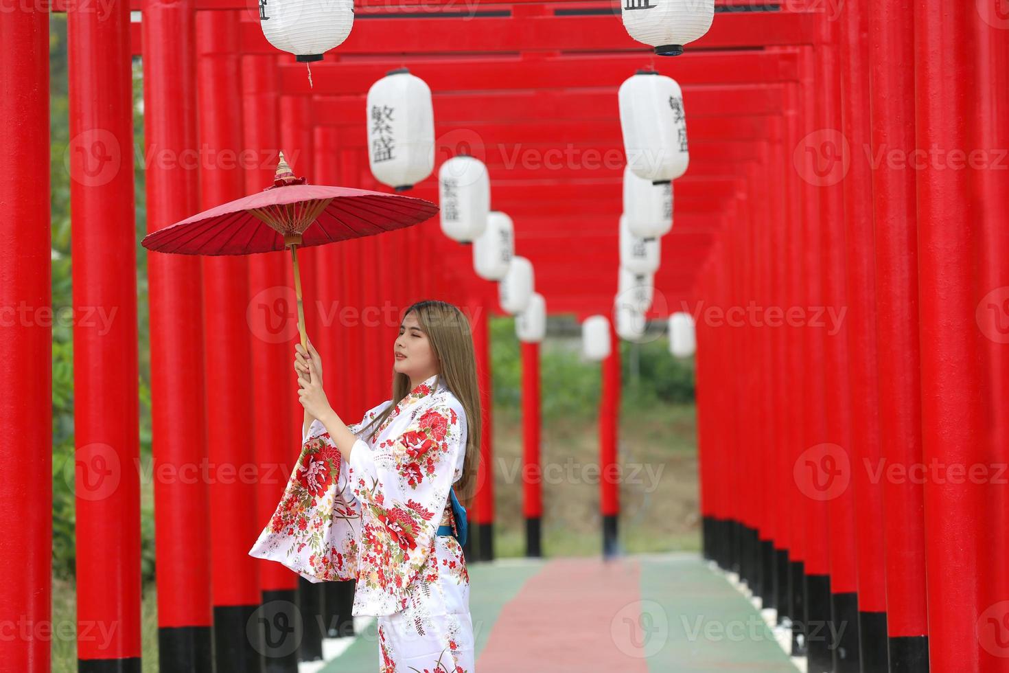 giovane ragazza asiatica che indossa kimono abiti tradizionali giapponesi e ombrello rosso. foto