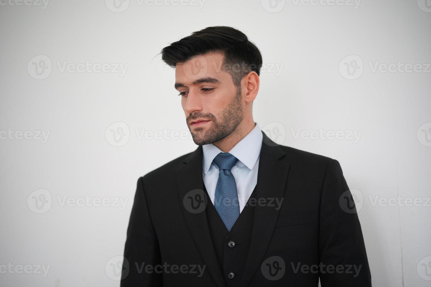 elegante giovane uomo bello caucasico su sfondo bianco, ritratto di moda in studio. foto