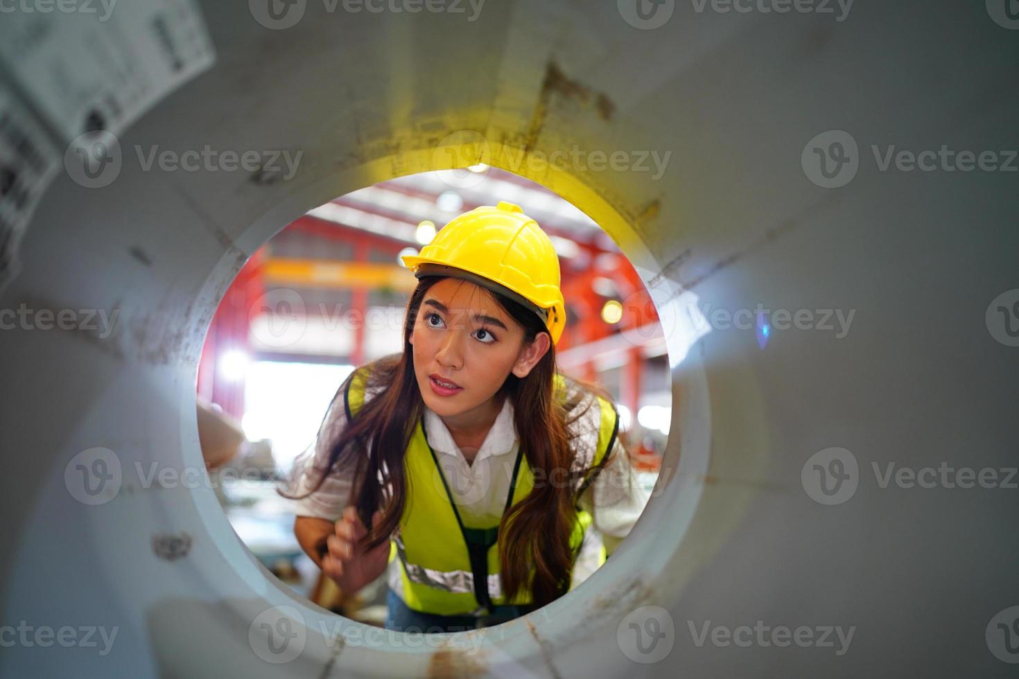 caposquadra o lavoratrice lavoratrice presso il sito di fabbrica controlla la macchina o i prodotti in loco. ingegnere o tecnico che controlla materiale o macchina sull'impianto. industriale e di fabbrica. foto