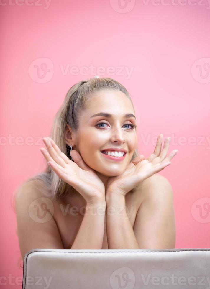ritratto di giovane donna sorridente su sfondo rosa foto