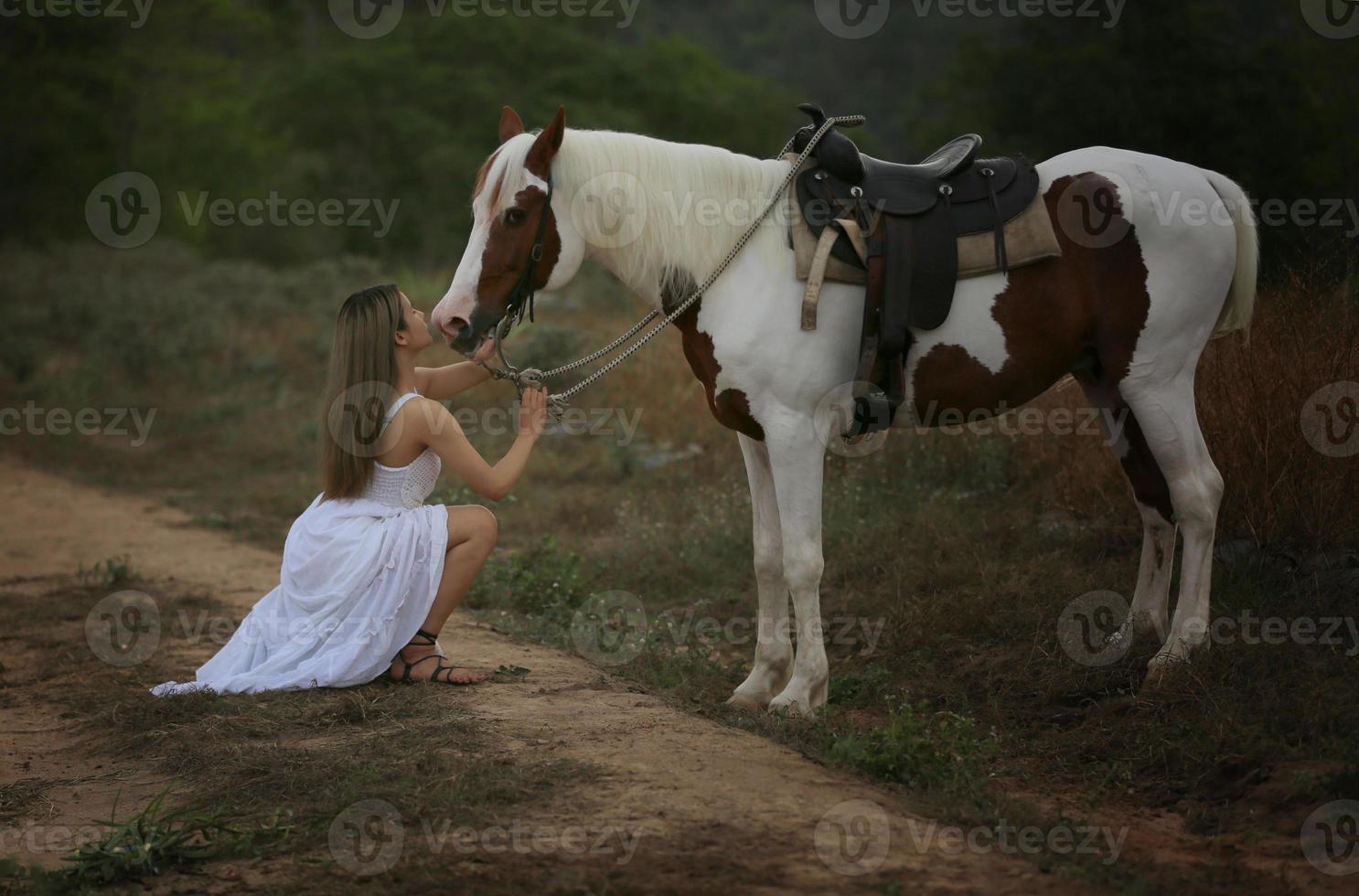 giovane donna con il suo cavallo nella luce del tramonto di sera. fotografia all'aperto con ragazza modella. umore dello stile di vita foto