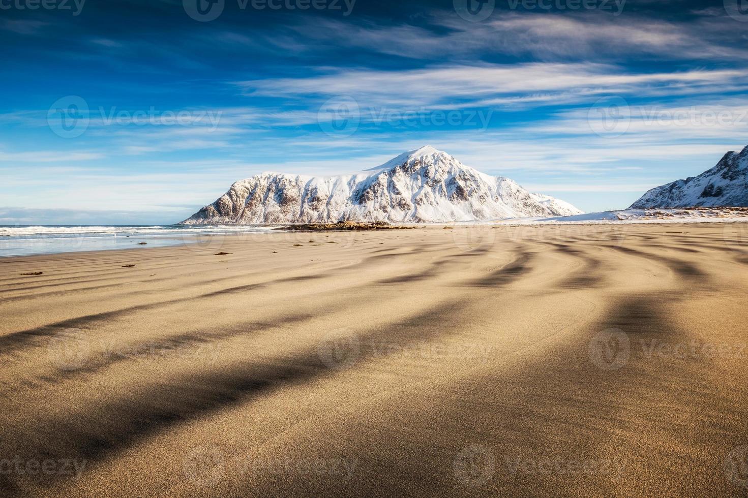 solco naturale di sabbia con montagna di neve e cielo blu foto