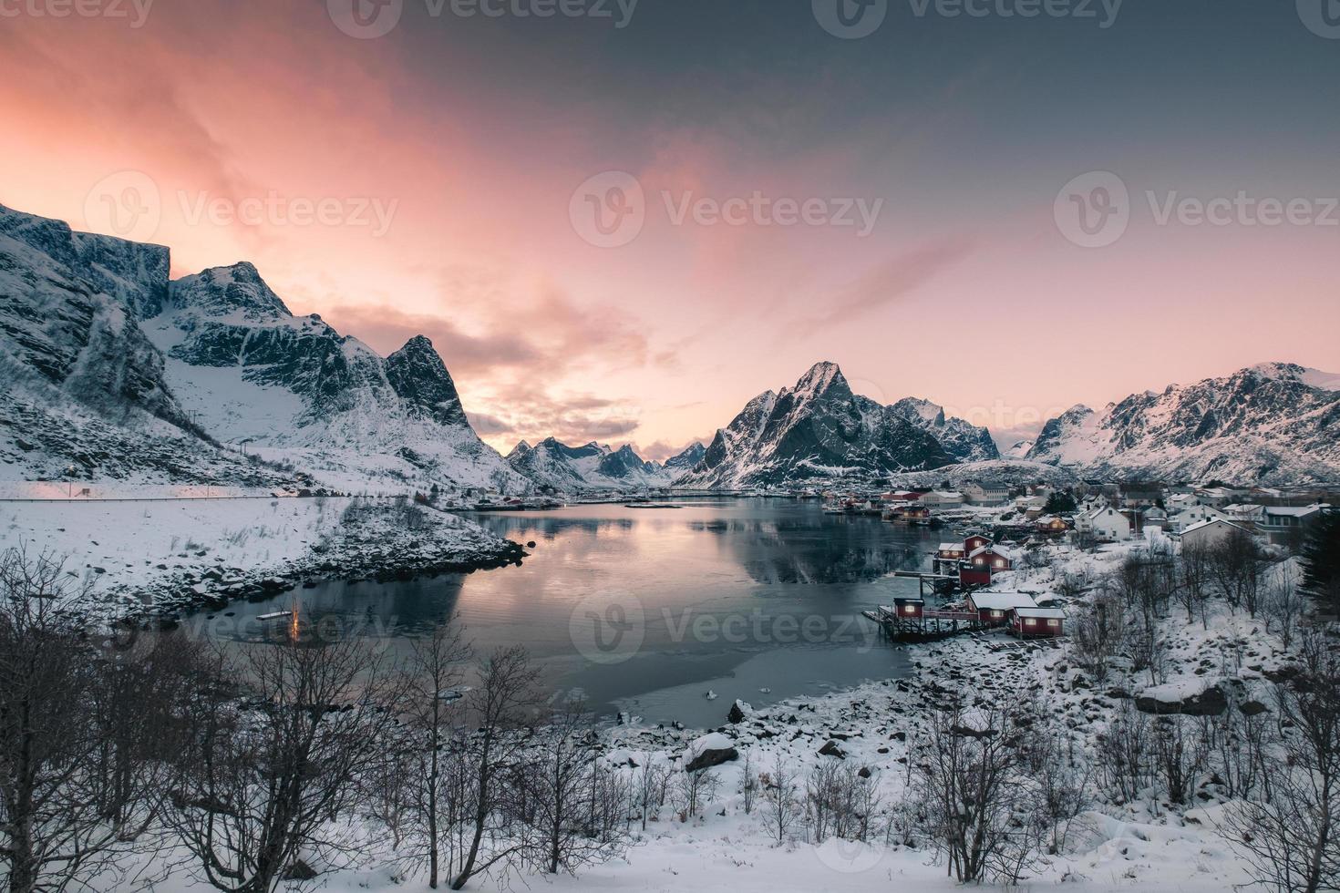 villaggio di pescatori in montagna di neve con cielo al tramonto sulla costa foto