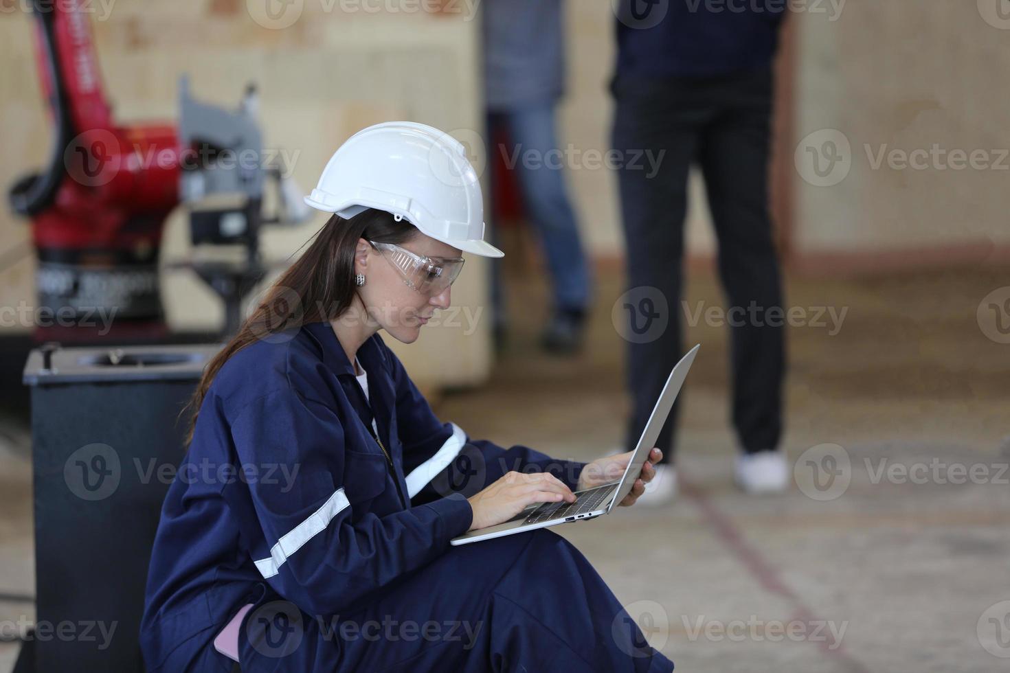 ingegnere industriale o lavoratore che indossa un casco mentre si trova in una fabbrica industriale pesante. la manutenzione cercando di lavorare su macchinari industriali e controllare l'installazione del sistema di sicurezza in fabbrica. foto