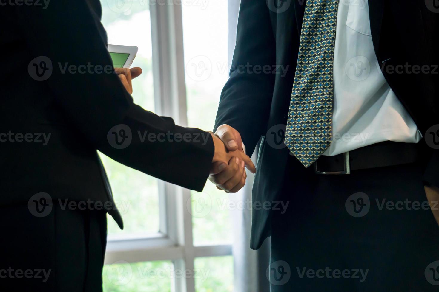 uomini d'affari che si stringono la mano dopo il successo delle trattative foto