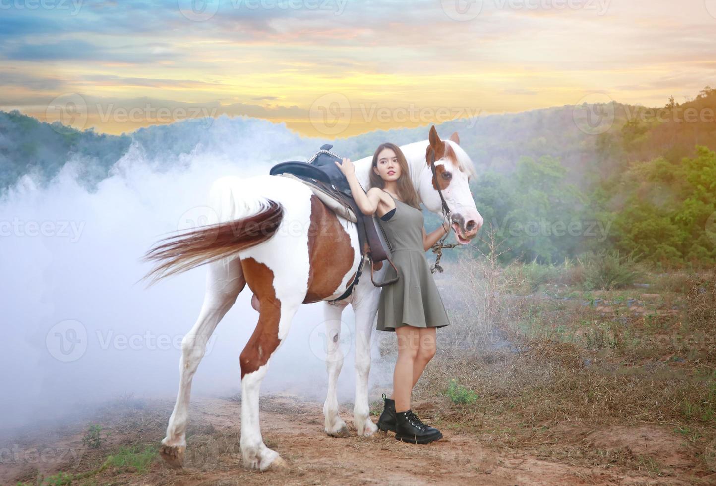 giovane donna con il suo cavallo nella luce del tramonto di sera. fotografia all'aperto con ragazza modella. umore dello stile di vita foto