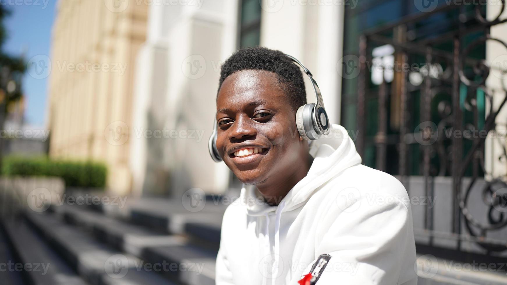 uomo afroamericano che si diverte a camminare nel centro della città - giovane ragazzo felice che si gode il tempo al tramonto all'aperto - stile di vita della generazione millenaria e concetto di atteggiamento positivo delle persone foto