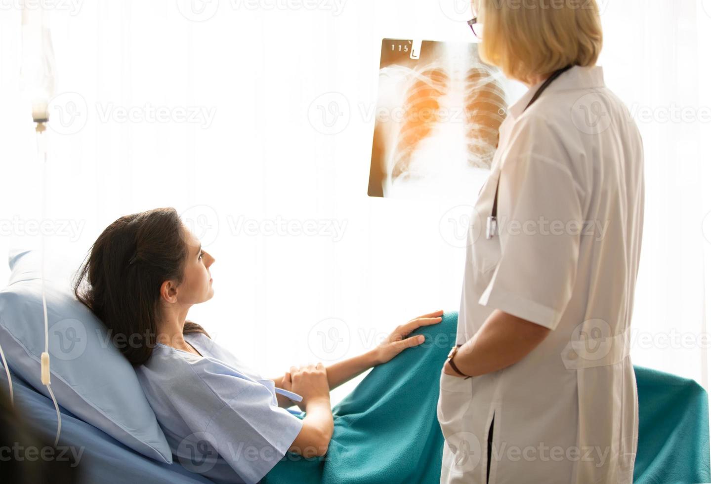 la dottoressa mostra l'immagine della pellicola a raggi X alla paziente e le spiega. foto