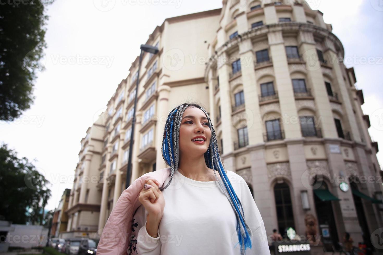 ritratto di giovane ragazza con i capelli blu, adolescente in piedi sulla strada come vita urbana. foto