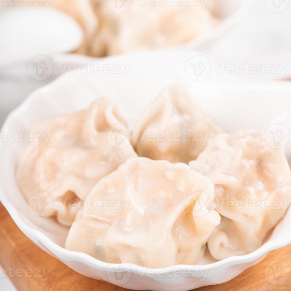 gnocchi di gyoza di maiale bolliti freschi e deliziosi, jiaozi su sfondo bianco con salsa di soia e bacchette, primo piano, stile di vita. concetto di design fatto in casa. foto