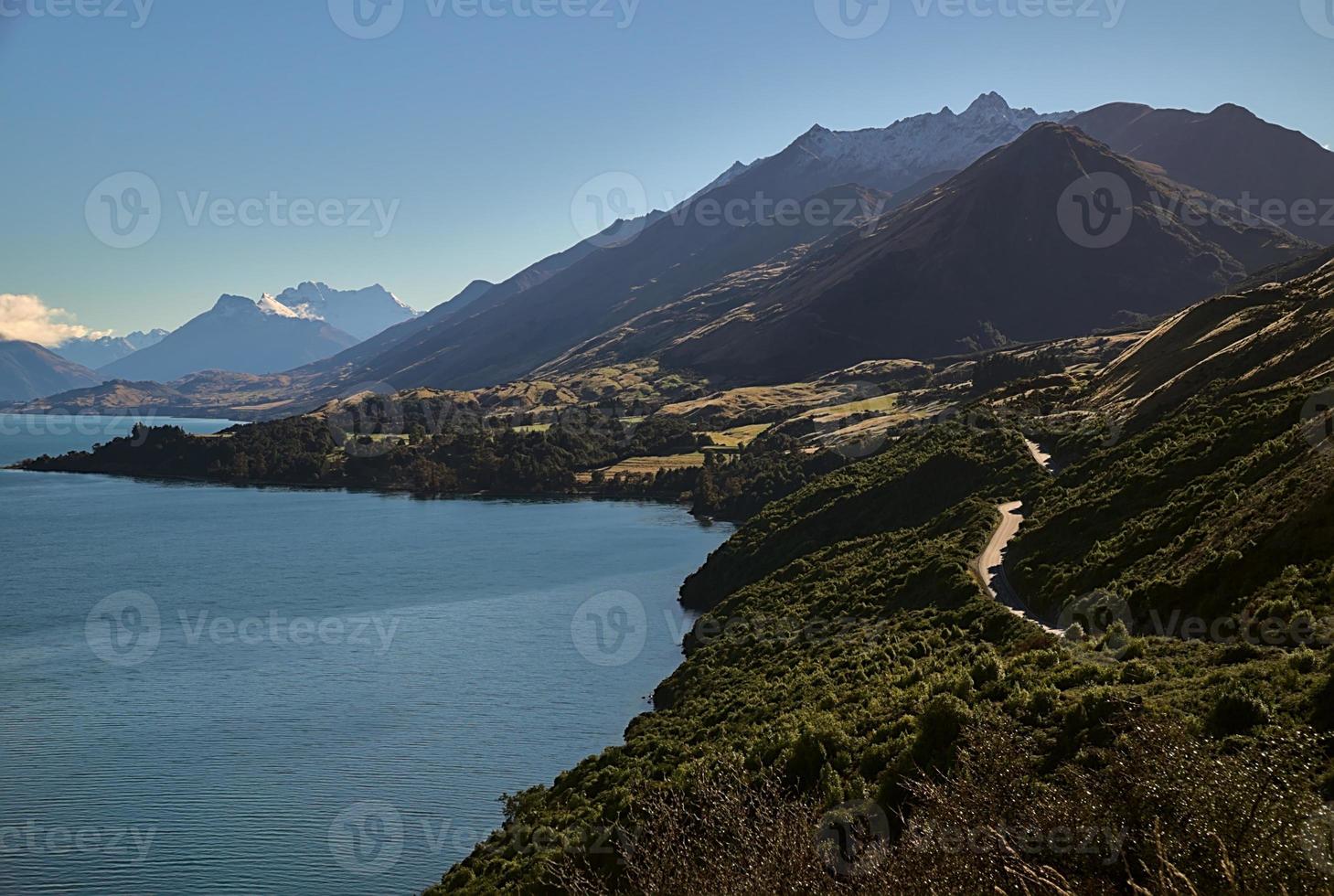 strada per le montagne vicino al lago foto