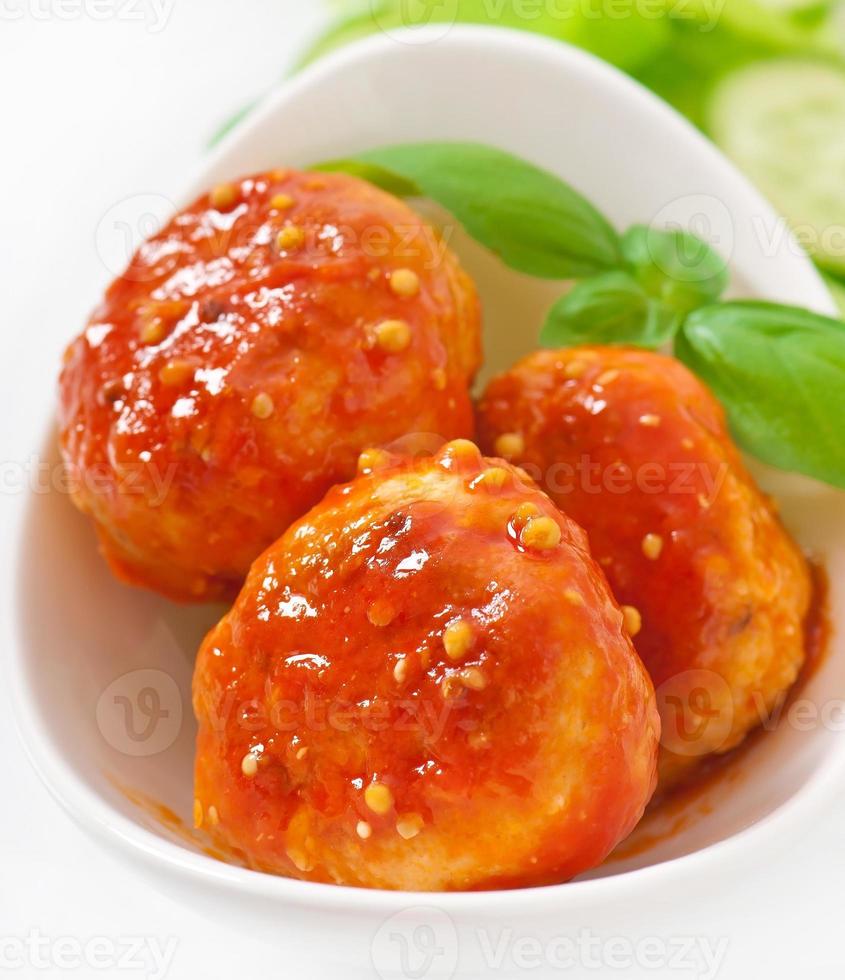 polpette al sugo, decorate con foglie di basilico foto