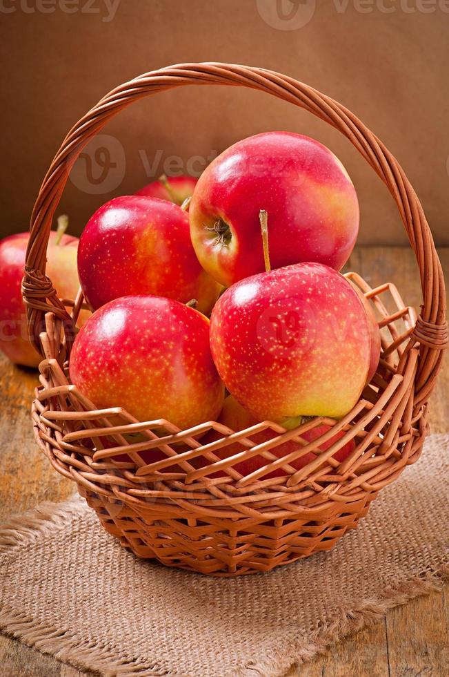mele in un cestino su fondo di legno foto