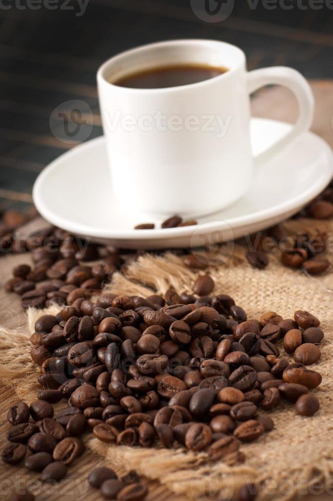 vista del primo piano di una tazza di caffè, zucchero di canna e chicchi di caffè foto