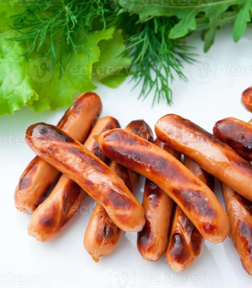 salsicce grigliate alla brace e un'insalata di verdure fresche foto