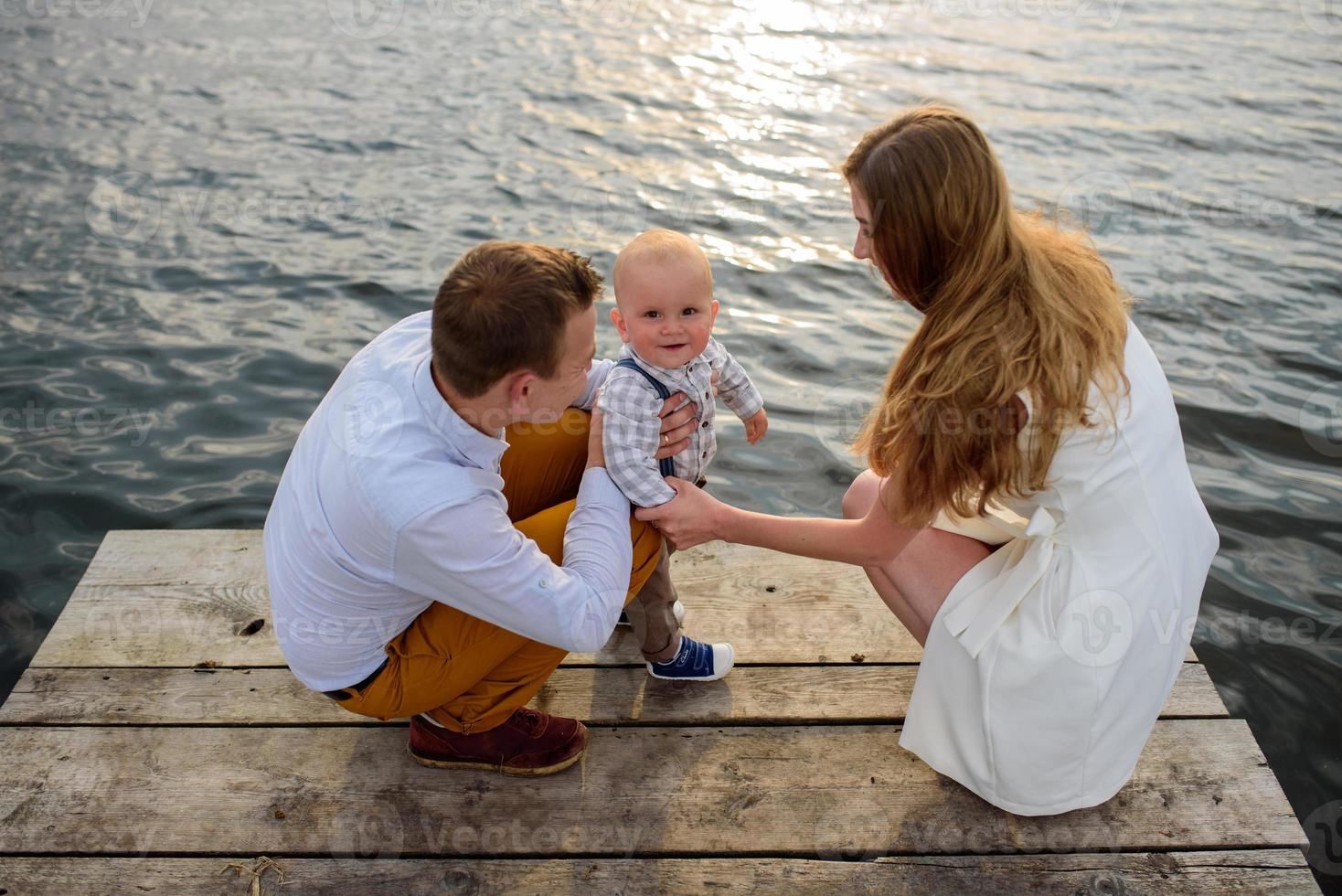 padre e madre guidano per mano il figlio di un anno. foto