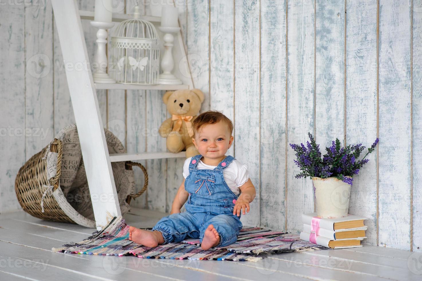 la bambina di un anno sorride e si siede. foto