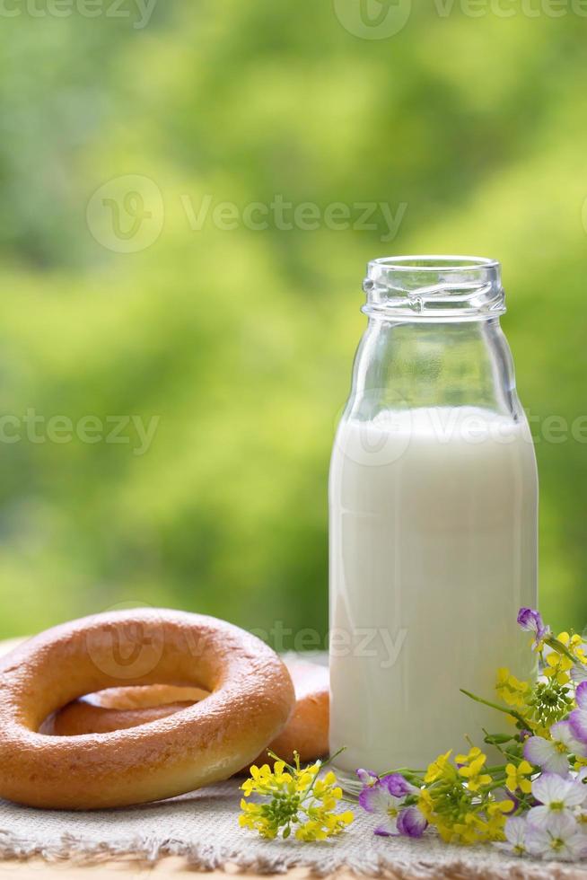 bottiglia di latte e bagel in estate foto
