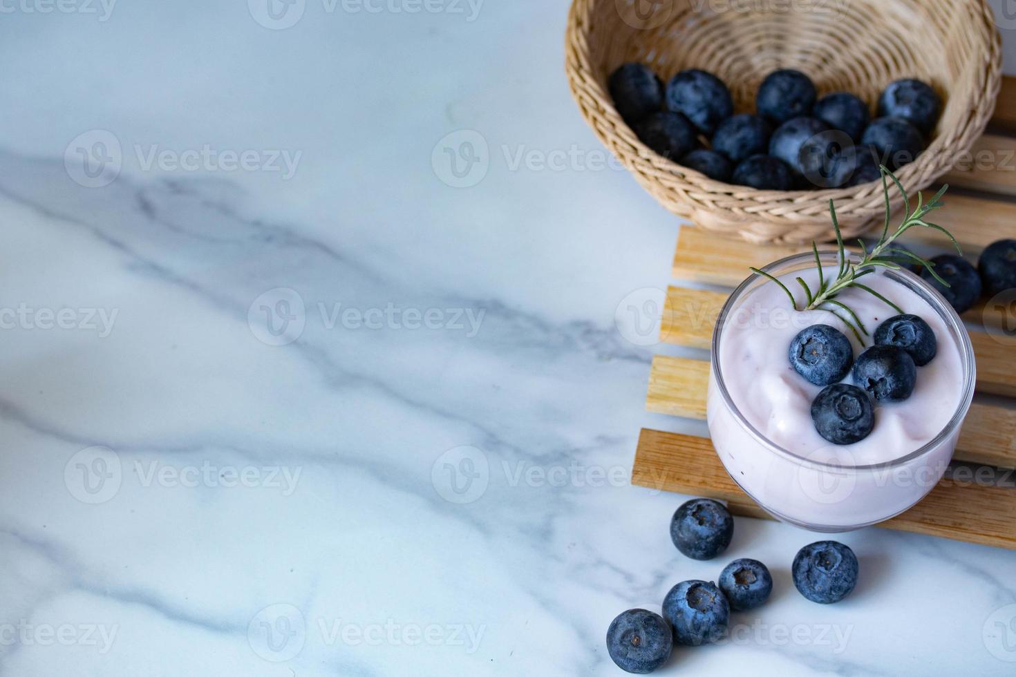 yogurt fresco ai mirtilli in un bicchiere trasparente foto