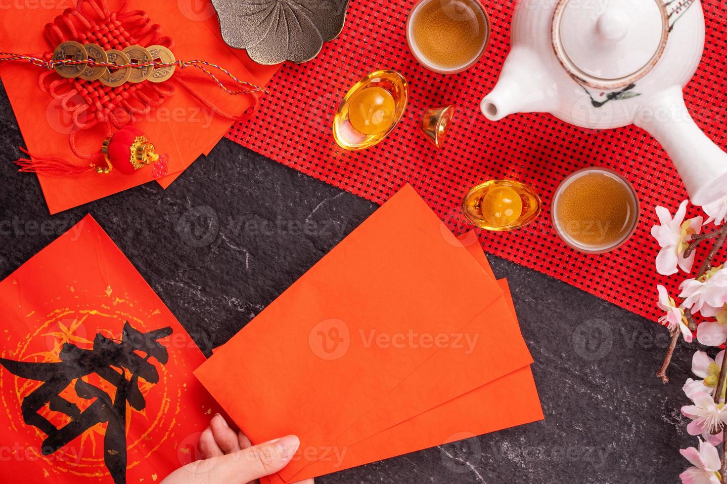 concetto di design del nuovo anno lunare cinese di gennaio - donna che tiene, dà buste rosse ang pow, hong bao per soldi fortunati, vista dall'alto, distesi, sopra la testa. la parola 'chun' significa primavera in arrivo. foto