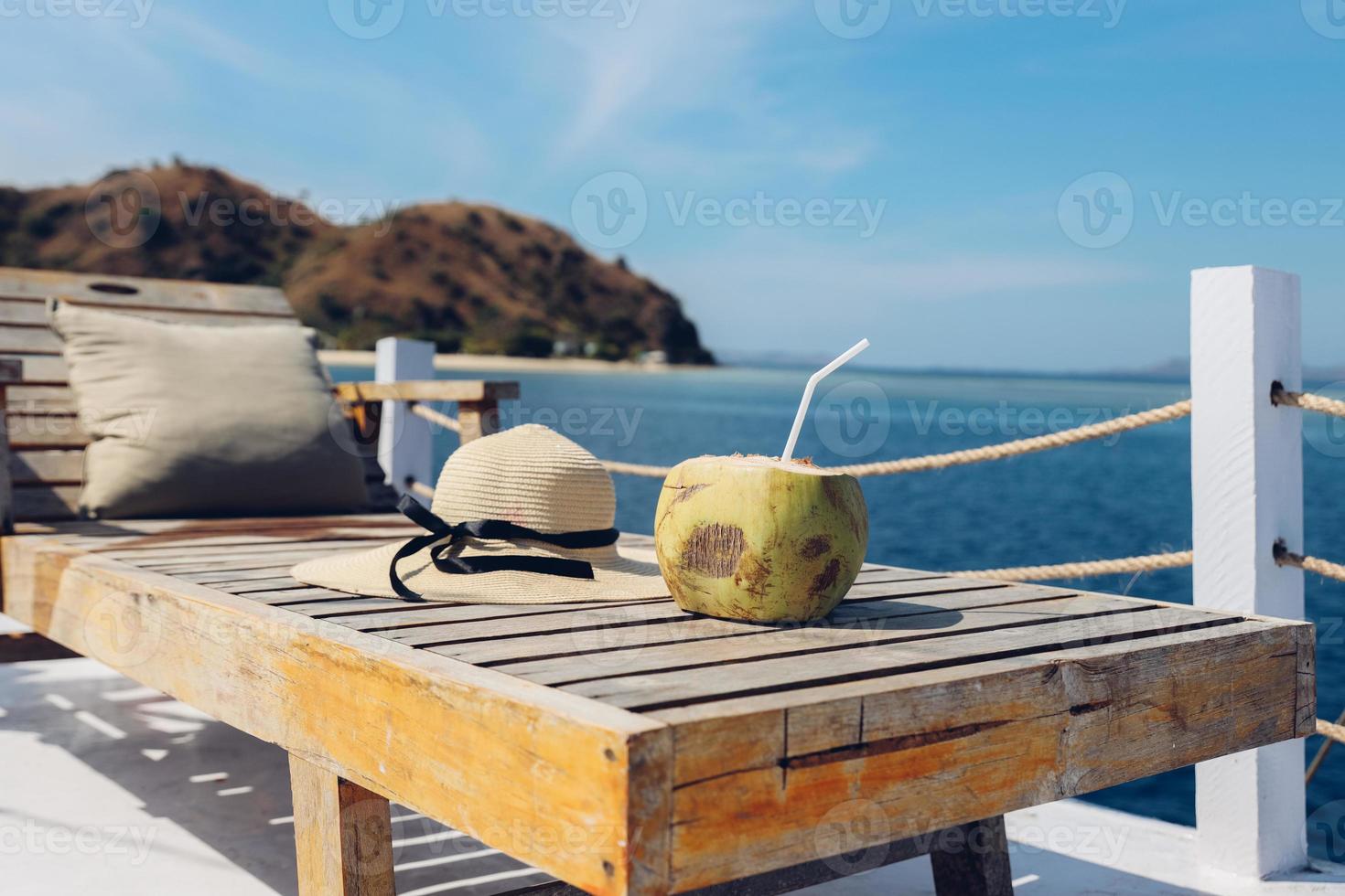 cocco e cappello estivo su sedia rilassante in legno per lo sfondo delle vacanze foto