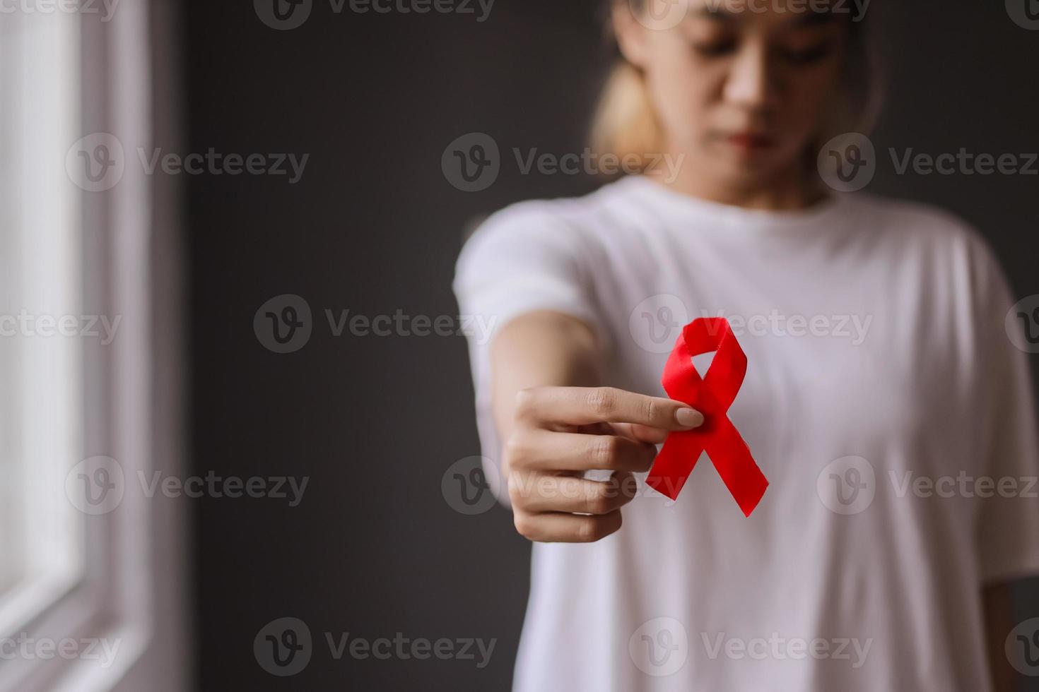 donna che tiene il nastro rosso per la campagna contro il cancro al seno foto
