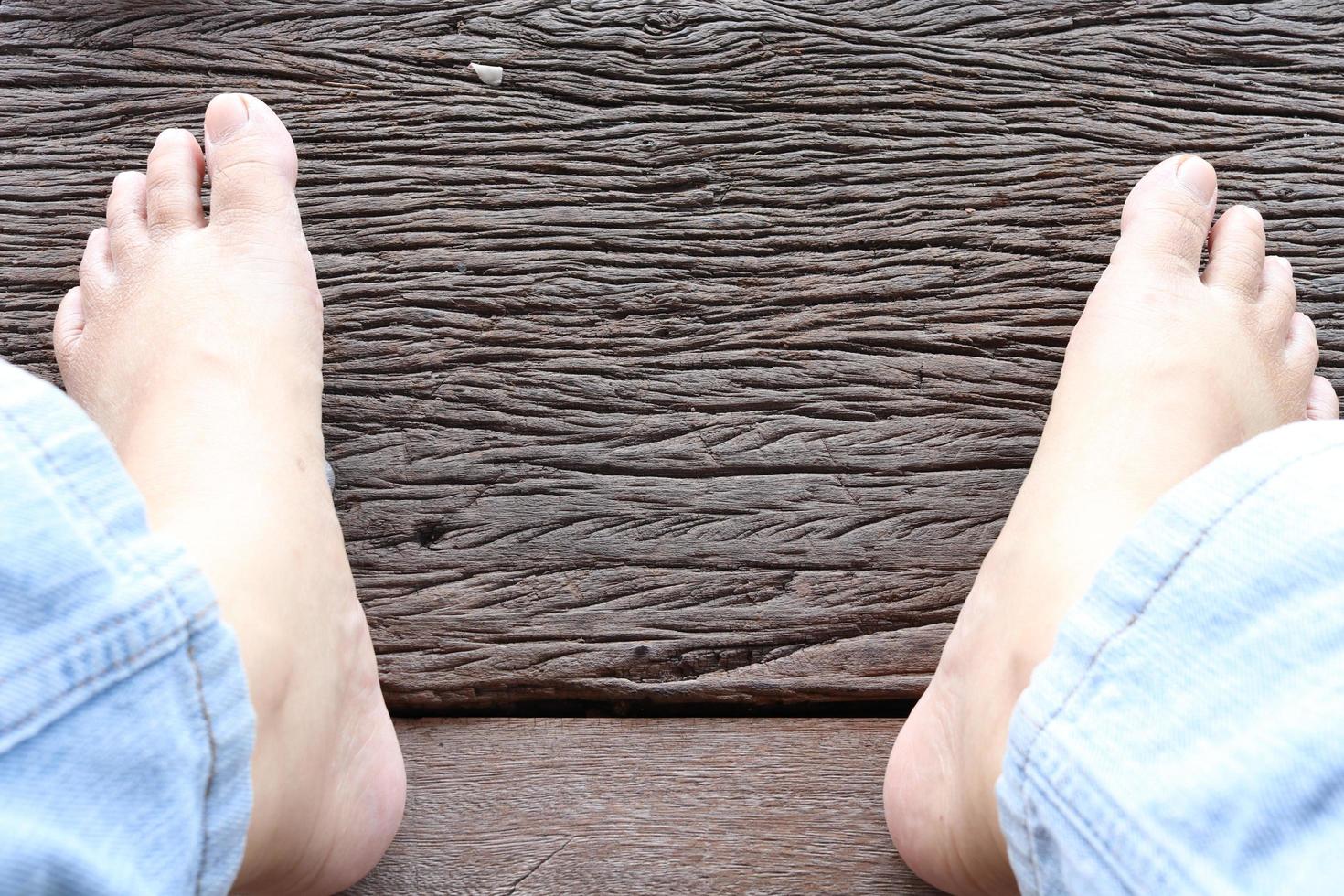 i piedi nudi sono su fondo di legno vecchio marrone. foto