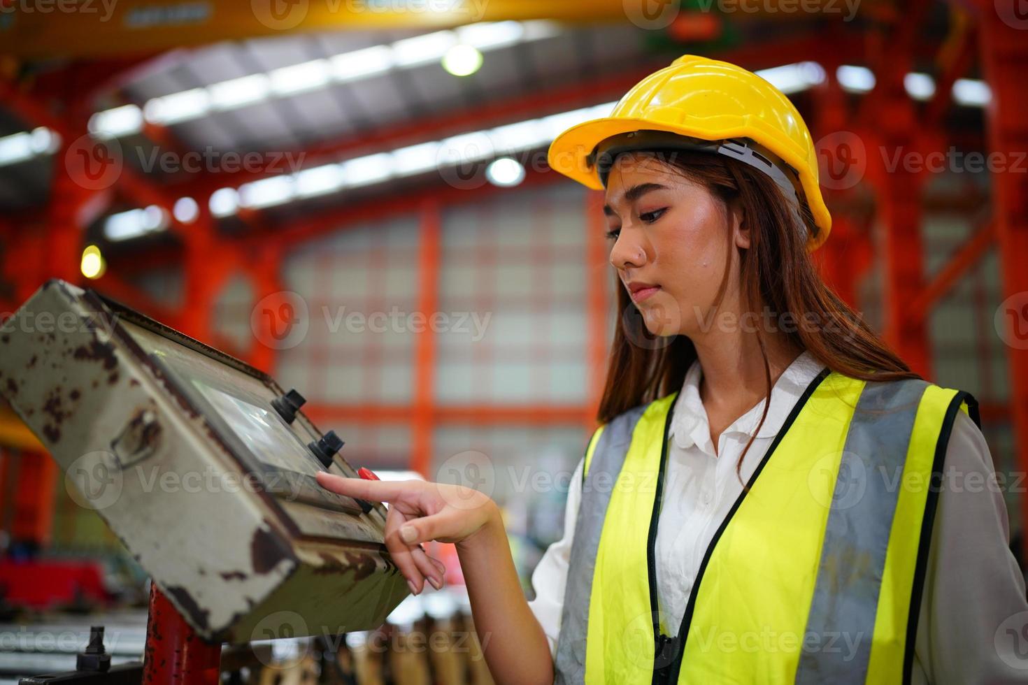 caposquadra o lavoratrice lavoratrice presso il sito di fabbrica controlla la macchina o i prodotti in loco. ingegnere o tecnico che controlla materiale o macchina sull'impianto. industriale e di fabbrica. foto