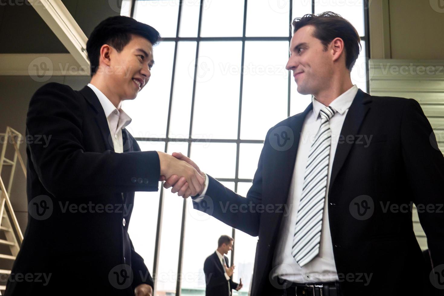 stretta di mano dell'uomo d'affari per il lavoro di squadra di fusione e acquisizione di affari, negoziazione riuscita, stretta di mano, due uomini d'affari si stringono la mano con il partner per celebrare la partnership e il concetto di affare foto