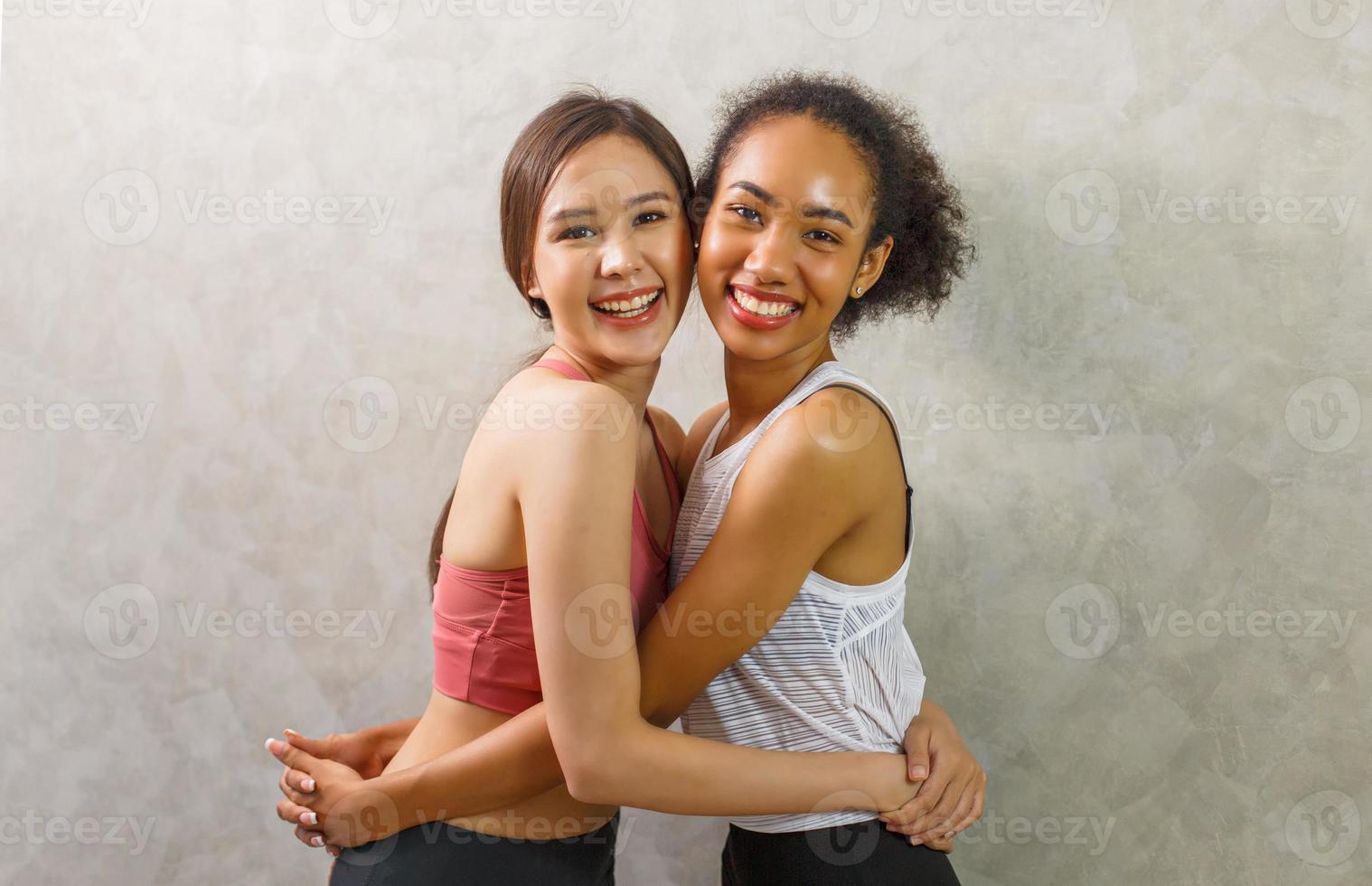 il ritratto di stile di vita di due giovani amici divertenti su abbigliamento sportivo si divertono e fanno finta di volti. atmosfera da festa a casa. giornata internazionale della donna. gruppo di tre giovani donne felici che sorridono. foto