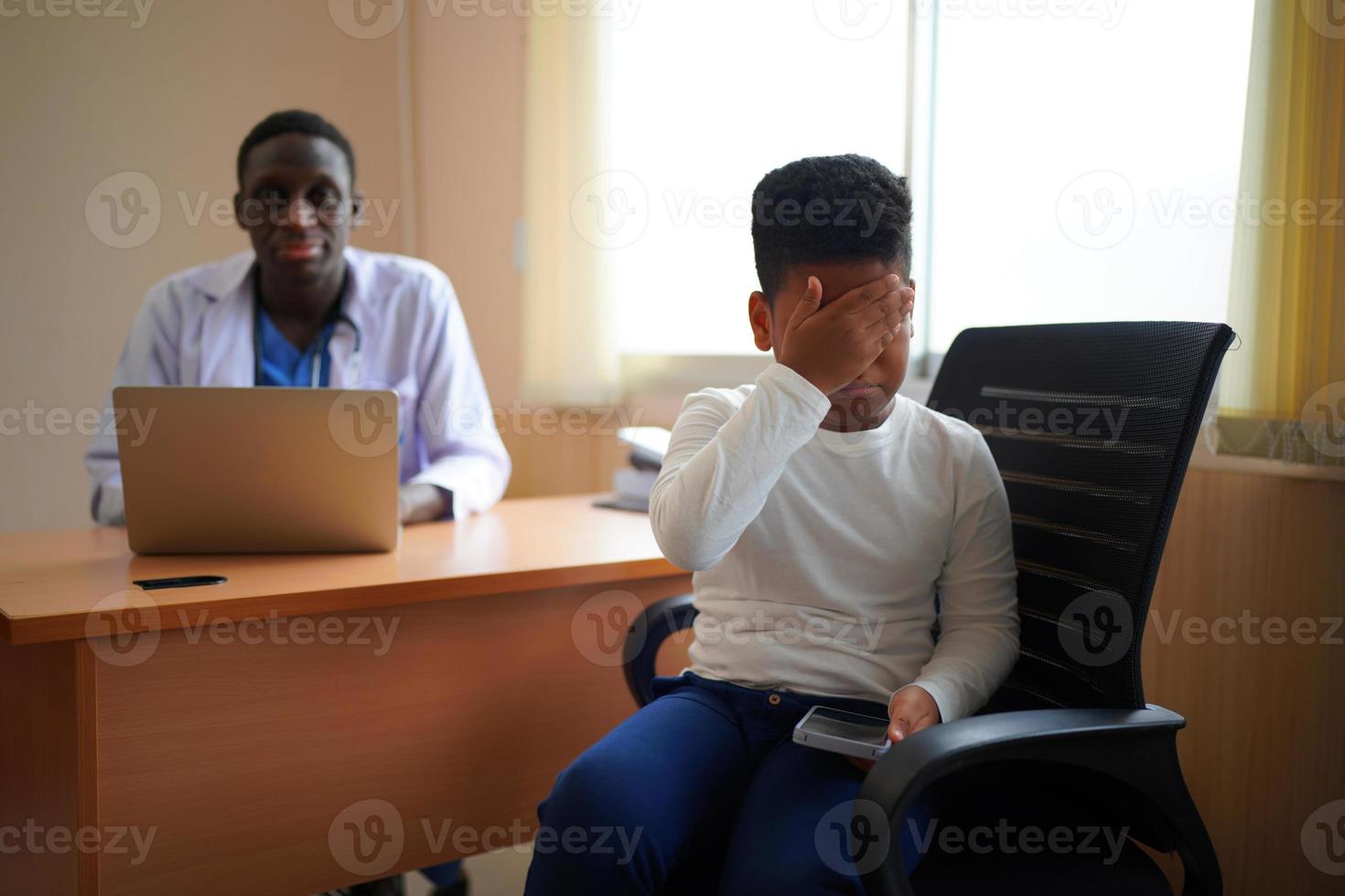 medico della pelle nera che controlla il corpo del bambino in clinica. foto