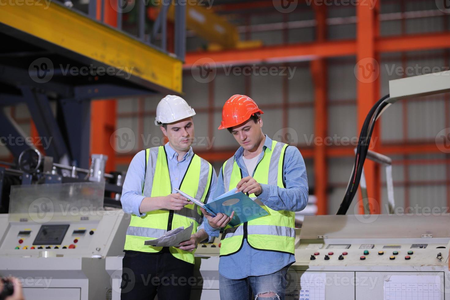 il caposquadra o il lavoratore del settore lavora presso il sito di fabbrica controlla la macchina o i prodotti in loco. ingegnere o tecnico che controlla materiale o macchina sull'impianto. industriale e di fabbrica. foto