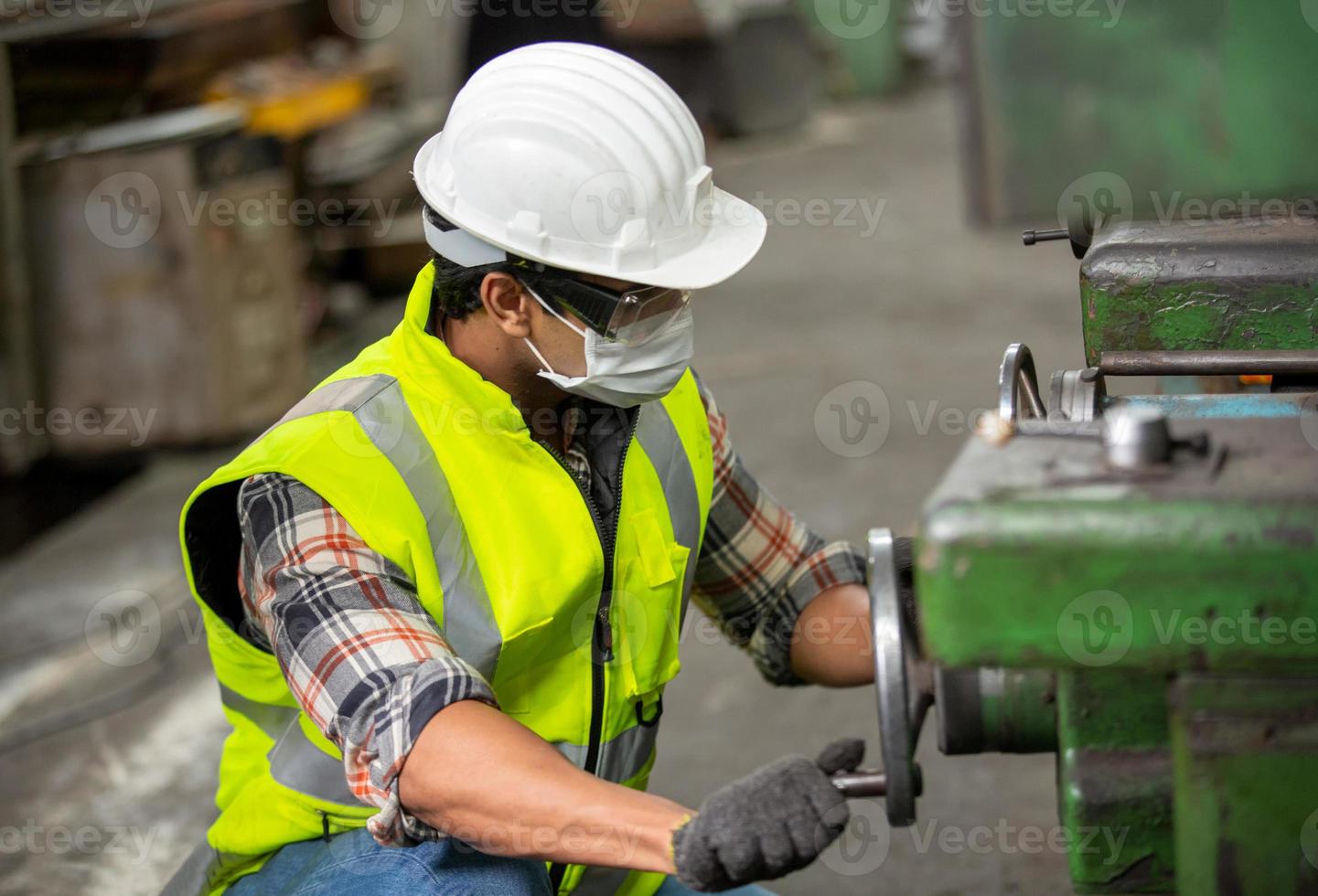 il lavoratore lavora in fabbrica controlla la macchina nella linea di prodotti o i prodotti in loco. ingegnere o tecnico che controlla materiale o macchina sull'impianto. industriale e di fabbrica. foto