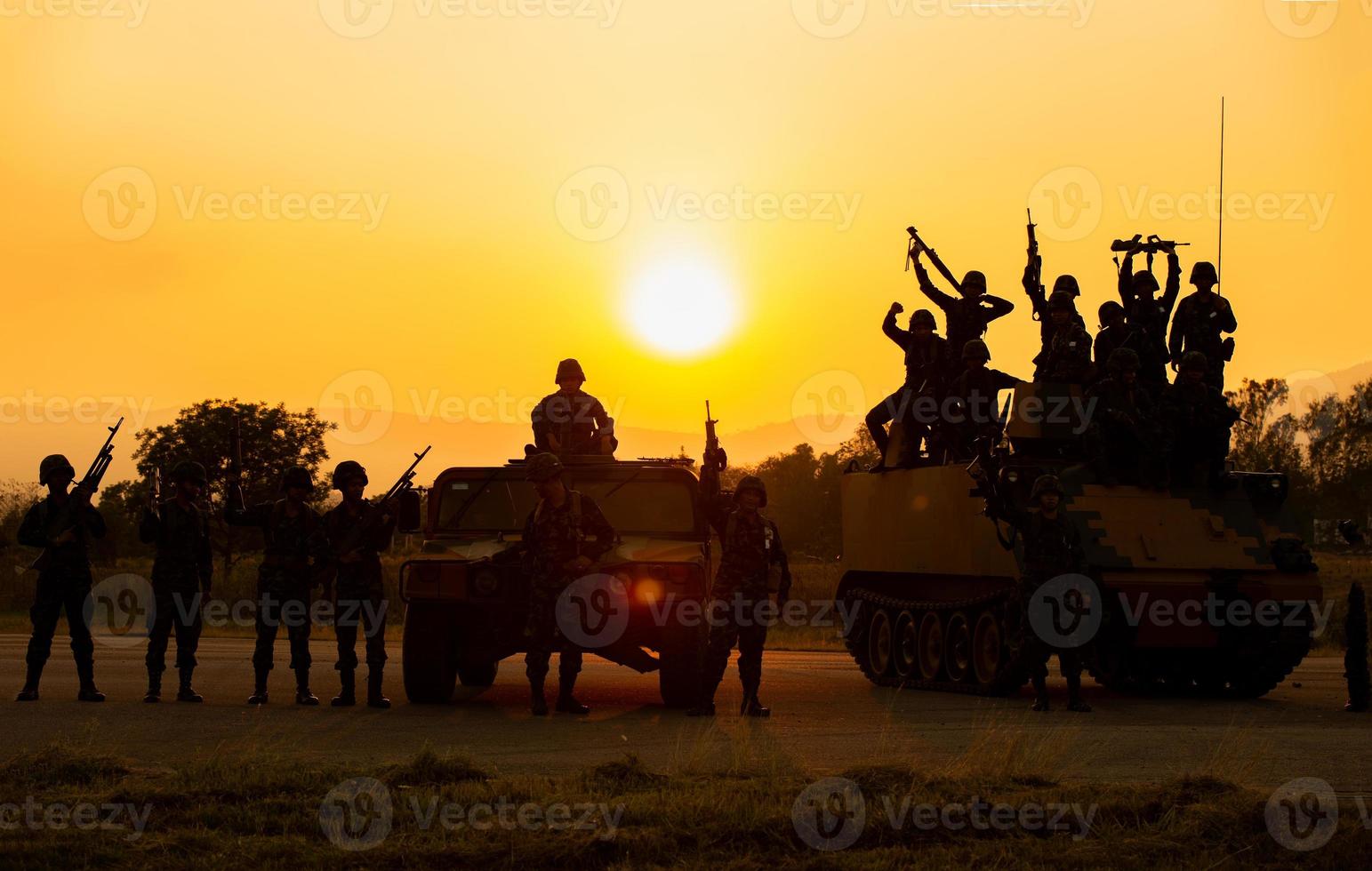 sagome di soldati dell'esercito nella nebbia contro un tramonto, squadra di marines in azione, circondato da fuoco e fumo, sparando con fucile d'assalto e mitragliatrice, attaccando il nemico foto