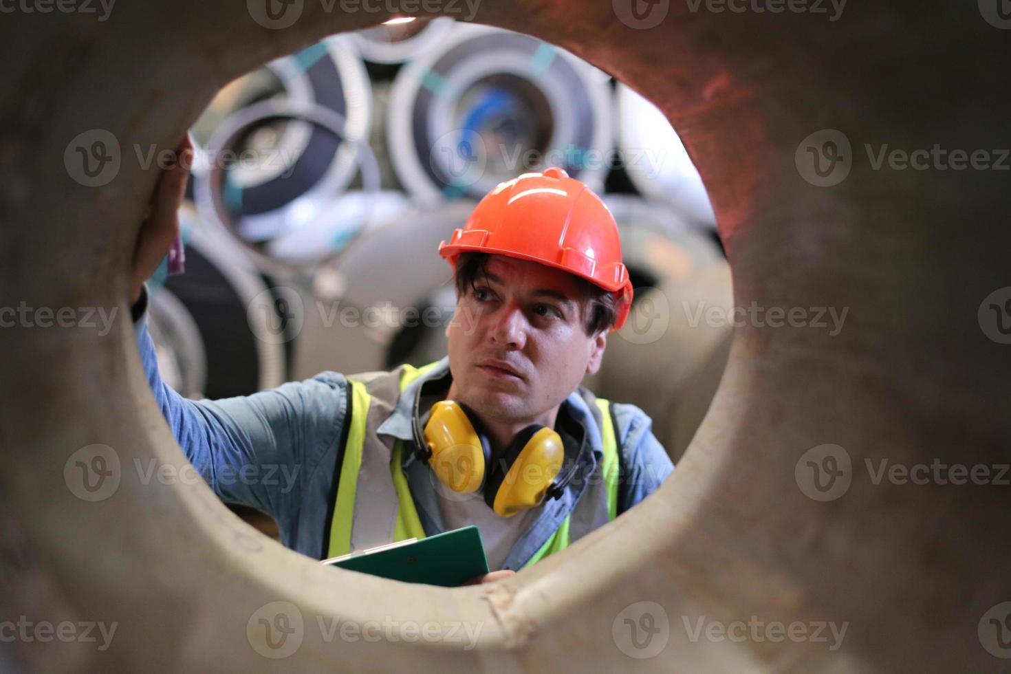 il caposquadra o il lavoratore del settore lavora presso il sito di fabbrica controlla la macchina o i prodotti in loco. ingegnere o tecnico che controlla materiale o macchina sull'impianto. industriale e di fabbrica. foto