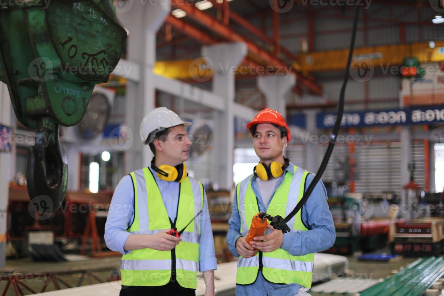 il caposquadra o il lavoratore del settore lavora presso il sito di fabbrica controlla la macchina o i prodotti in loco. ingegnere o tecnico che controlla materiale o macchina sull'impianto. industriale e di fabbrica. foto