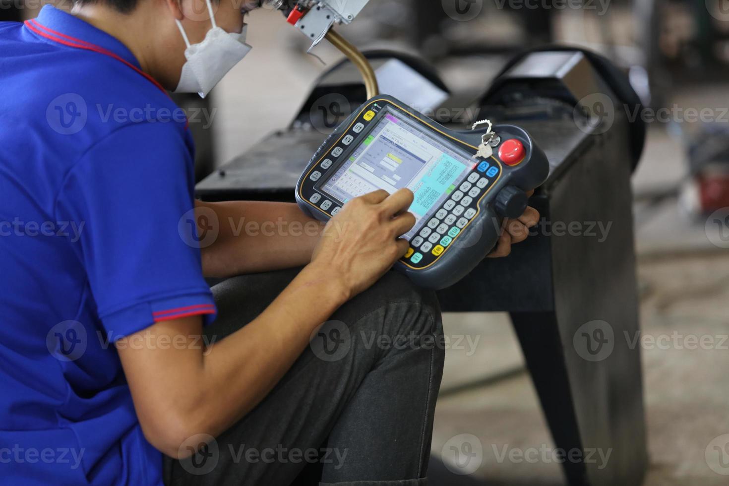 ingegnere industriale o lavoratore che indossa un casco mentre si trova in una fabbrica industriale pesante. la manutenzione cercando di lavorare su macchinari industriali e controllare l'installazione del sistema di sicurezza in fabbrica. foto