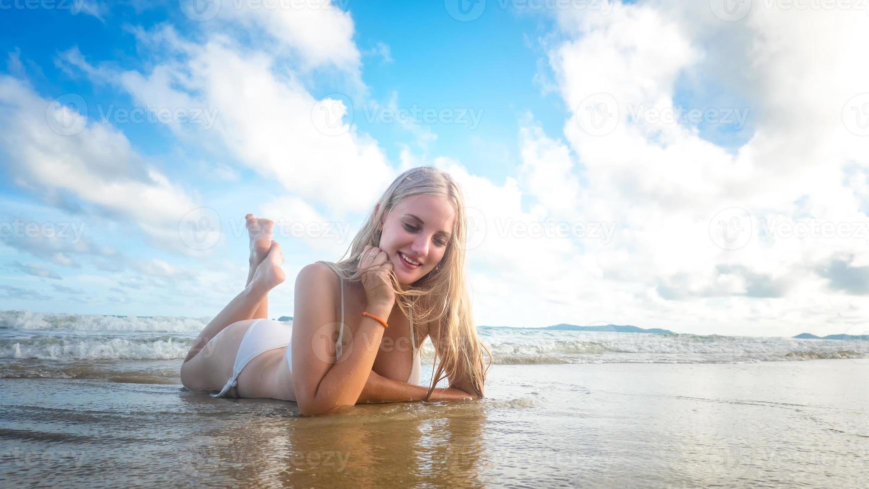 ritratto di una bella donna bionda godersi la sua estate sulla spiaggia. foto