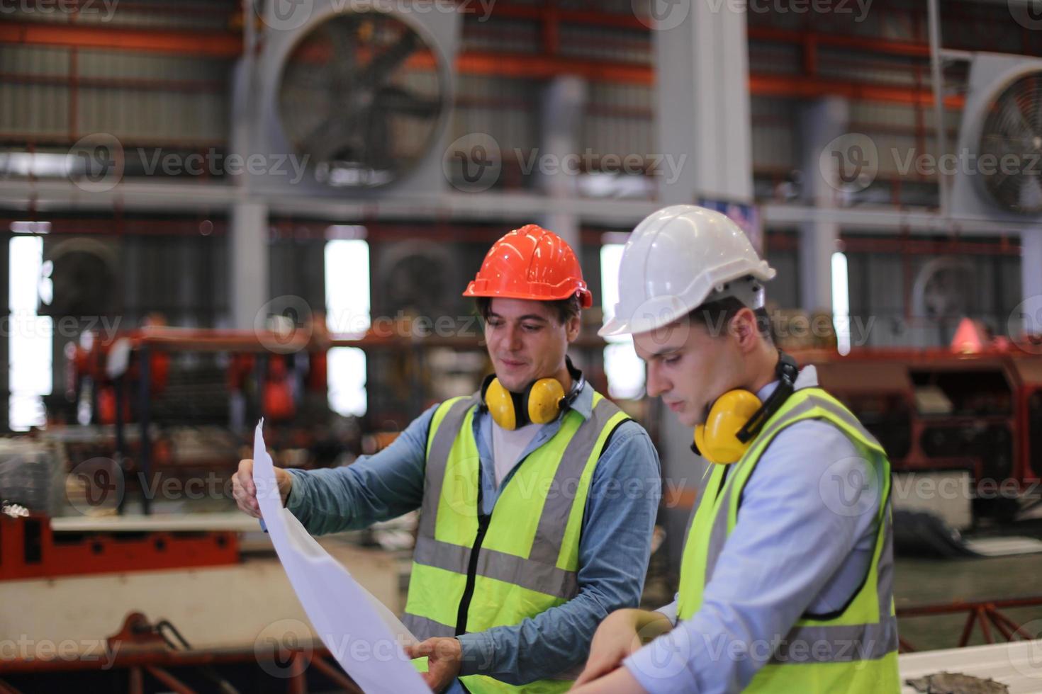 il caposquadra o il lavoratore del settore lavora presso il sito di fabbrica controlla la macchina o i prodotti in loco. ingegnere o tecnico che controlla materiale o macchina sull'impianto. industriale e di fabbrica. foto