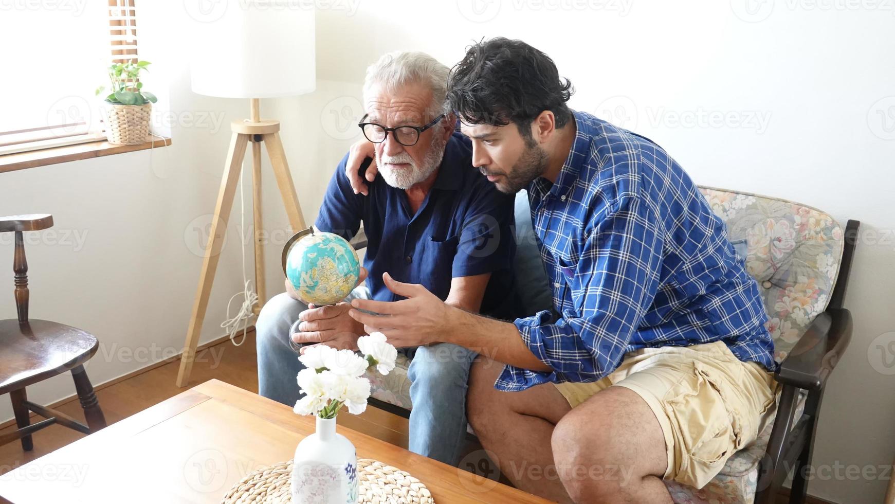 un ritratto del figlio adulto dei pantaloni a vita bassa e del padre anziano trascorrono del tempo insieme nel fine settimana a casa. foto