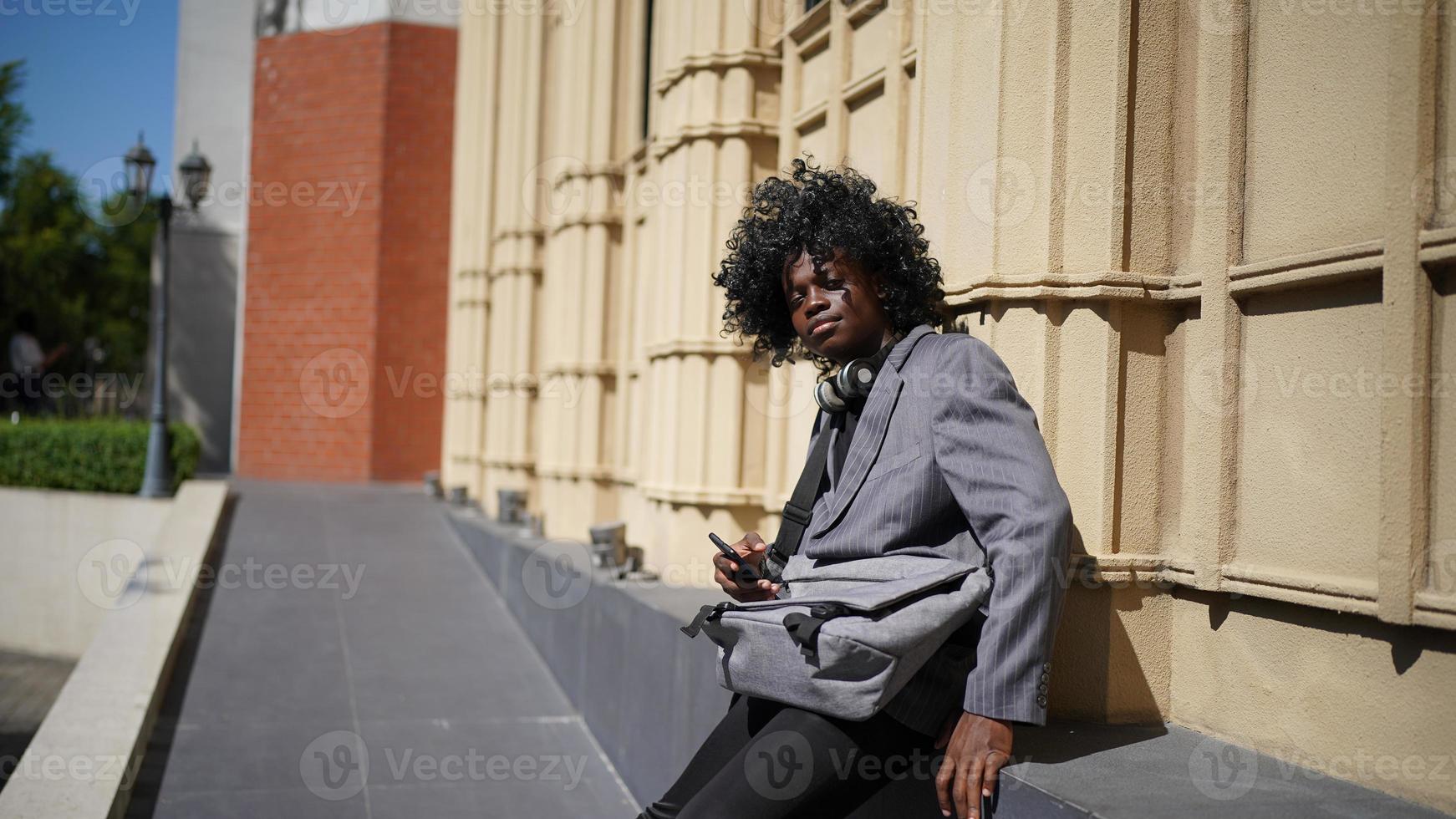 uomo afroamericano che si diverte a camminare nel centro della città - giovane ragazzo felice che si gode il tempo al tramonto all'aperto - stile di vita della generazione millenaria e concetto di atteggiamento positivo delle persone foto