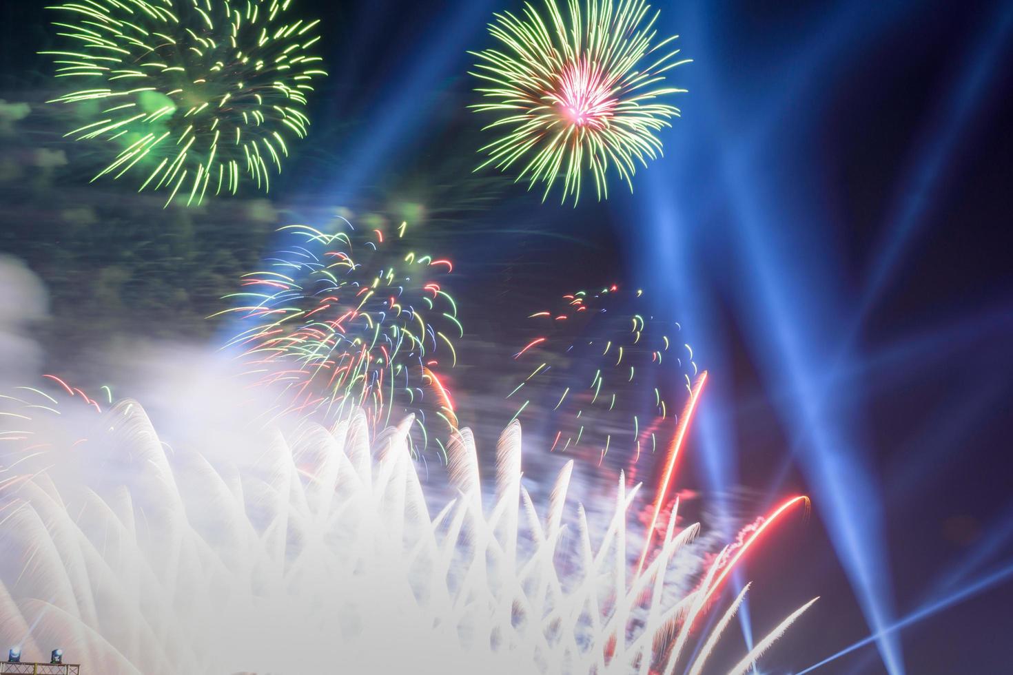 sfondo colorato di fuochi d'artificio con spazio libero per il testo. fuochi d'artificio colorati di notte illuminano il cielo con uno spettacolo abbagliante. foto