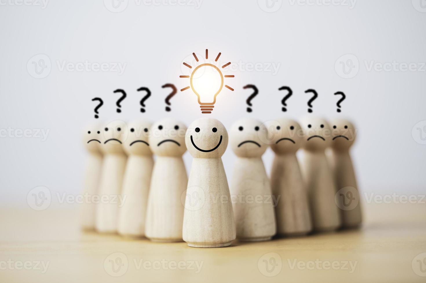 smiley umano in legno con lampadina e altri umani con punto interrogativo per il pensiero creativo e il concetto di soluzione di problem solving. foto