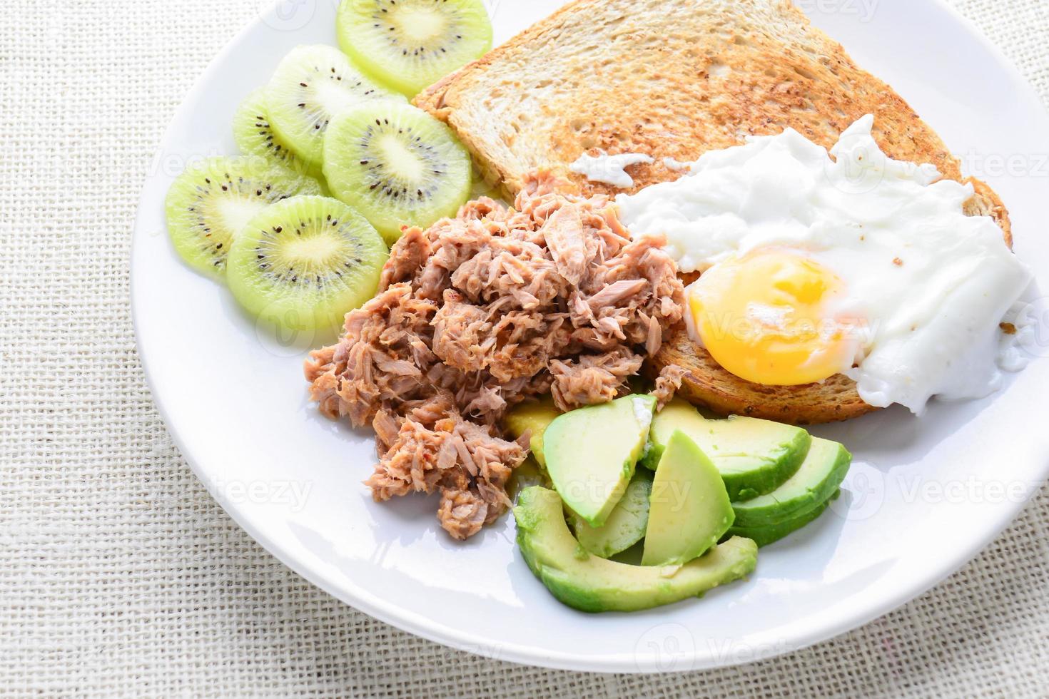 cibo pulito in stile moderno, pane, uova, insalata di tonno, kiwi e avocado foto