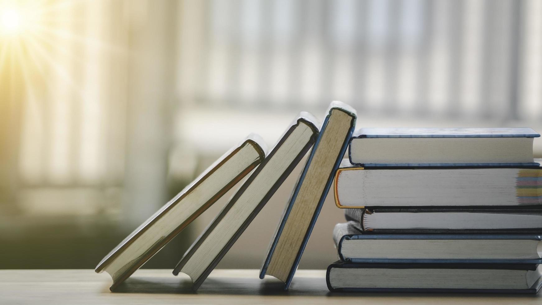 fila di libri, vecchi libri con copertina rigida d'epoca su tavola di legno. libro per la scuola e l'istruzione con lo spazio della copia. foto