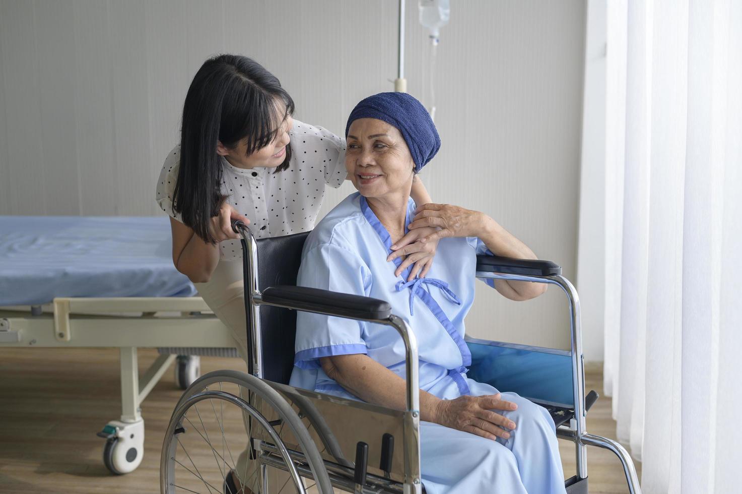 donna malata di cancro che indossa una sciarpa per la testa e sua figlia di supporto in ospedale, concetto di salute e assicurazione. foto